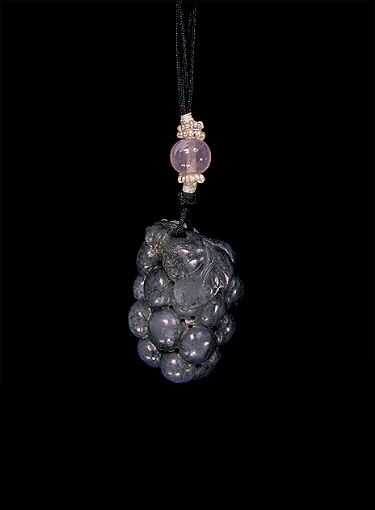 Reverse: Nephrite pendant, mutton fat with a large dark grey area, carved in the form of a squirrel that is scampering over a bunch of grapes with leaves.