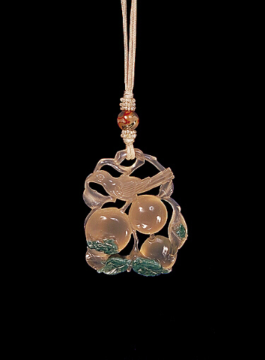 Chalcedony pendant, pale, translucent grey agate with a green chlorite skin, the grey colour carved with peaches and leaves and a bird, the green carved with leaves, small insects and a frog.