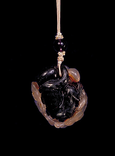 Reverse: Chalcedony pendant, pale beige and brown agate with a much darker brown area carved as a large monkey holding peaches amongst ruyi fungus.