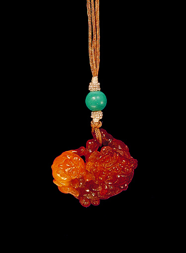 Amber pendant of the variety known as Baltic, bright yellow with darker translucent colour, carved in the form of a Fo dog with its young.